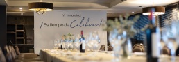 Mesa lista para la comida con photocall al fondo durante sesión de fotografía corporativa en even