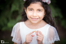 Retrato de Valentina sosteniendo la cadena que le ha regalado su madre durante su sesión de fotografías de comunión en Burlada.