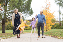 Fotografía familiar en Sarriguren de Liz y Jose paseando con sus hijas por el parque infantil.