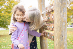 Fotografía familiar en Sarriguren de Liz dando un beso a Ángela mientras juegan en el parque infantil.