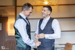 Laro y Gonzaga vistiéndose entre risas en una habitación del Hotel Tres Reyes de Pamplona durante su boda.